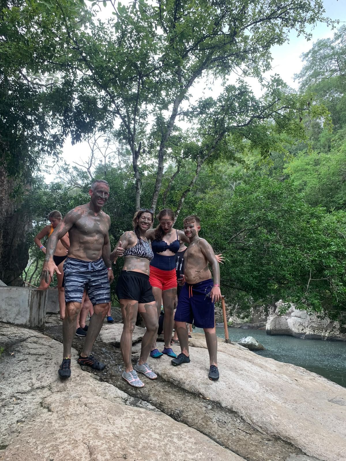 Familia con barro volcánico junto al río